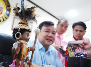 With a Dagoy doll on the foreground, City Mayor Jerry Treñas appears smiling while answering questions