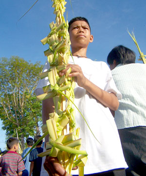 A boy holds palm fronds as he goes out of the church yesterday