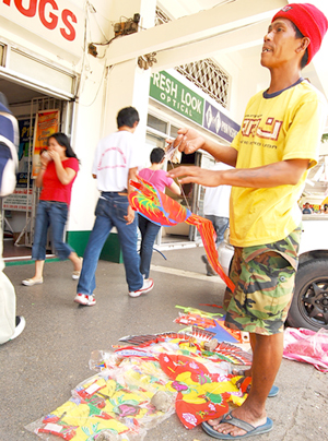 A man sells colorful kites in downtown Iloilo City