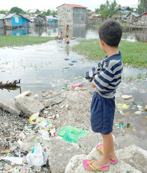 A boy looks at his friends playing on the water