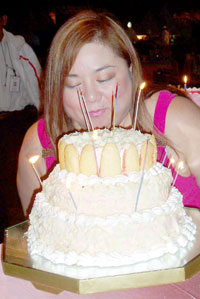 Marie Jean Cordero blows one of her cakes