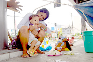 A mother joining the protest action in support of the transport strike feeds her son