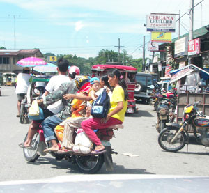 A fully-loaded single motorcycle or “skylab” brings passengers from the town proper