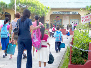 Schoolchildren, some of them assisted by their parents