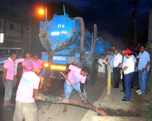 Personnel from Metro Manila Development Authority (MMDA) remove mud from the drainage