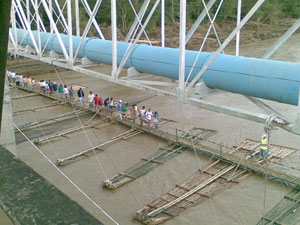 People walk through a makeshift bridge made of bamboo below the Tigum Bridge in Brgy. Tabucan, Cabatuan