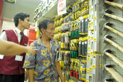 A sales attendant guides Manong Doming in buying his chosen carpentry tools.