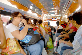 Passengers of a public utility jeepney cover their nose as they pass by Jaro area.