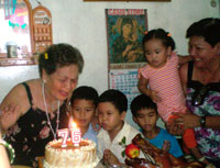 Blowing the birthday candle with her great grandchildren.
