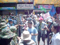 Police and military anti-riot squads block the rallyists along Araneta Street near the public plaza.