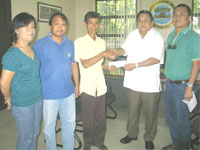 Provincial Administrator Enrique Pinongan (2nd from right) turns over the check worth P35,000 to representatives of Tayap Upland Farmers Association for the Organic Coffee Growing Project, as Arthur Alvañez (right) of PEMO look on.