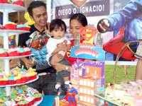 Diego, with Papa and Mommy, claps while guests sing his birthday song.