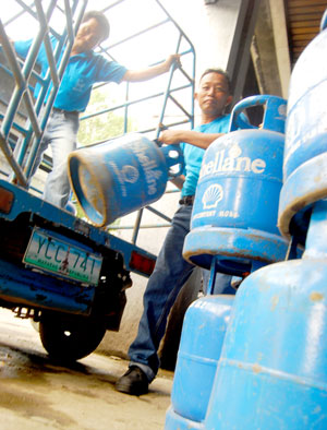Haulers unload liquefied petroleum gas (LPG) tanks from a truck in downtown Iloilo.