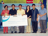Mendiola and DOLE Asst Regional Director Crispin Danog with the Launio family while holding their check from Globe