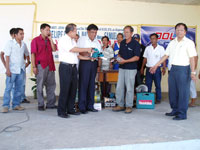 Dole 6 Assistant Director Crispin Dannug Jr, Board Member Roy Habaña and Engr Filomeno Sonza turn over the equipment to Benito Ferrer.