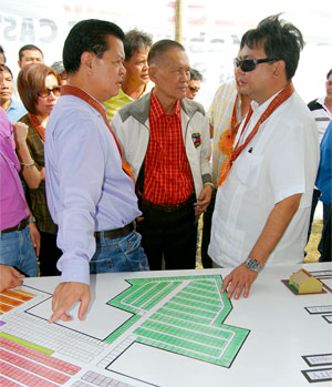Vice Pres. Noli De Castro and City Mayor Jerry Treñas huddle just before the start of the ground breaking ceremony for the P35 million Iloilo Disaster core shelter housing project at the San Isidro, Jaro relocation site.