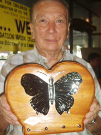 Sculptor Tony Wuthrich holds a wall hanging design he made. He is the grandfather of a special child.