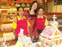 Tinapayan's Owa Que and her staff with the Gingerbread Village.