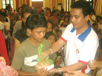 Nonoy Evan Contreras hands a gift pack to a kid-beneficiary.