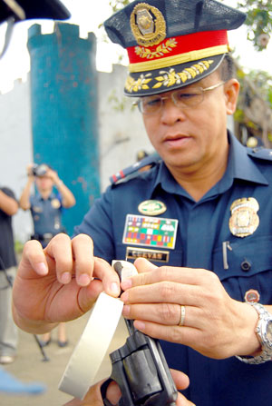 Chief Supt. Isagani R. Cuevas, Police Regional Office 6 director, leads the taping of the muzzle of the firearms of police officers at Camp Martin Delgado in Iloilo City yesterday.