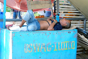 A vendor in downtown Iloilo City, appearing exhausted after a busy day, sleeps on top of his stall printed with City Mayor Jerry Treñas's slogan “Uswag Iloilo”. 