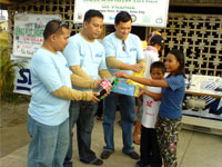 PLDT employees give stuff to the children.