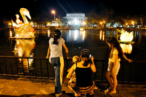 People in Bacolod City enjoy the sight of floating “giant swans” at the Capitol lagoon which glows at night.