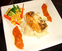 Pan-fried Chilean Sea Bass on Mashed Potatoes with Carrot and Ginger Coulis and Veggies.