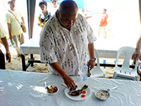 Governor Nava tastes one of entries in the seafood cooking contest.