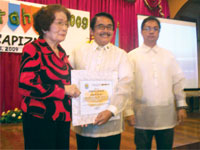 Annie Fagutao, sister of Dr Adolfo Bellosillo, receives the award in his behalf.