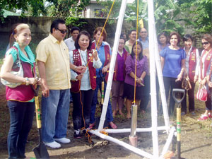 The time capsule is being lowered by Zonta Area Director Sandra Gomez, with the assistance of Mayor Jerry P. Treñas.
