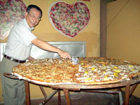Department of Tourism Envoy for the Asean and SKAL Club International Cebu President Charles Lim proudly cuts what could be the biggest commercially hand-made pizza in the world available for dining. 