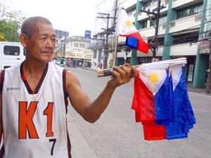 A man sells miniature Philippine flags to motorists in downtown Bacolod City.