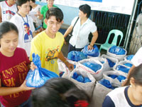 Student  volunteers distribute bags of clothes.