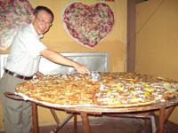 Department of Tourism Envoy for the Asean and SKAL Club International Cebu President Charles Lim proudly cuts what could be the biggest commercially hand-made pizza in the world available for dining.