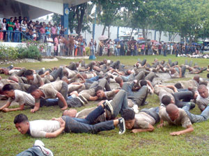New police recruits endure a snake roll after their oathtaking yesterday at the parade grounds of Camp Martin Delgado.