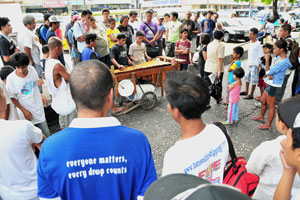 Street musicians using improvised instruments attract the attention of bypassers at the Bacolod City public plaza.