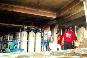 Personnel from Iloilo City Bureau of Fire Protection (BFP) check on the damage caused by fire