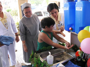 A boy washes his hands with soap and water from a water jug set up at the St. Paul’s Hospital in Iloilo City