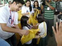 Akihiro distributes bags to kids.