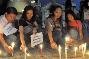 Media practitioners in Iloilo City light candles at the Jaro Cathedral compound