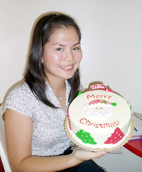 Meyan Lim, Red Ribbon marketing services officer, presents a Santa's Wish Cake.
