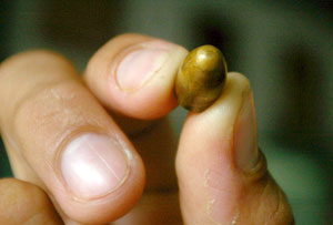 A policeman shows a stray bullet. Three injuries from stray bullets were recorded in Molo