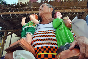 A devotee holds images of Sr. Sto. Niño while waiting for the arrival of the pilgrim image of the Holy Child