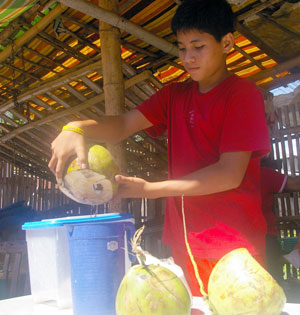 A teen prepares buko (coconut) juice in order to sell this to those who wish to quench their thirst especially during this summer season.