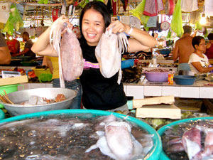 A pretty girl shows off a pair of delicious looking big squids at the Boracay wet market