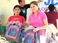 Angelu de Leon and a recipient show the school bags.