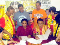 Signing of the MOA by Lion President Dr. Greg Sancho, MJF on behalf of Iloilo City (Host) Lions Club and Punong Barangay Fred Caturas