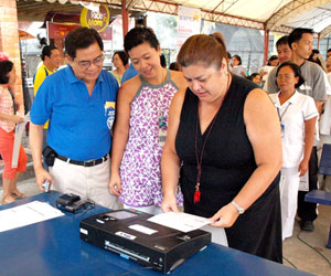 TNT Publishing, Inc. Managing Director Marichel Teves-Magalona is seen trying out the Precinct Count Optical Scanner (PCOS) machine