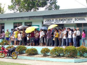 Long lines of voters wait for their turn to vote outside the polling centers in Jibolo Elementary School in Janiuay, Iloilo